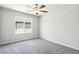 Neutral bedroom with plush gray carpet, ceiling fan, and a view from the bright window at 4039 Beech Fern Ave, North Las Vegas, NV 89084