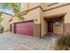 Exterior of tan home with a three car garage, brick paved driveway and desert landscaping at 4039 Beech Fern Ave, North Las Vegas, NV 89084