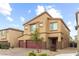Two-story home with a three car garage, desert landscaping, and brick driveway at 4039 Beech Fern Ave, North Las Vegas, NV 89084