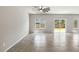 Open-concept living room with ceiling fan, tiled floors, large windows, and sliding glass doors to the backyard at 4039 Beech Fern Ave, North Las Vegas, NV 89084