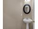 Powder room features pedestal sink, round mirror, and neutral wall color at 4225 Telstar Ct, North Las Vegas, NV 89032