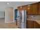 Kitchen featuring stainless steel refrigerator, wood cabinets and granite countertops at 4225 Telstar Ct, North Las Vegas, NV 89032