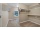 A clean and spacious walk-in closet with carpet, white shelving, and a bright window for natural light at 4225 Telstar Ct, North Las Vegas, NV 89032