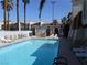 Community pool with lounge chairs and umbrellas near townhouses with terracotta roofs at 5006 Schumann Dr, Las Vegas, NV 89146