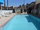 Community pool with lounge chairs and umbrellas set against a backdrop of stucco buildings at 5006 Schumann Dr, Las Vegas, NV 89146