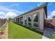 Beautifully landscaped backyard with artificial grass, covered patios, and a view of the home's exterior at 5095 E Long Leaf Ct, Pahrump, NV 89061