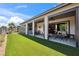 Expansive backyard featuring artificial grass, covered patios, and lush landscaping at 5095 E Long Leaf Ct, Pahrump, NV 89061