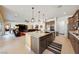 Open kitchen and living room area features an island with seating, and stainless steel appliances at 5095 E Long Leaf Ct, Pahrump, NV 89061