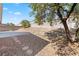 Desert landscaped backyard features rock, concrete patio, and mature tree at 5307 Wild Orchid St, North Las Vegas, NV 89031
