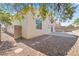 View of backyard with gravel landscaping, block wall, and patio area, partially shaded by a leafy tree at 5307 Wild Orchid St, North Las Vegas, NV 89031