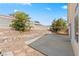 Spacious backyard with a concrete patio, trees, and rock landscaping at 5307 Wild Orchid St, North Las Vegas, NV 89031