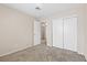 Bright bedroom featuring neutral walls, plush carpet, and a closet with sliding doors at 5307 Wild Orchid St, North Las Vegas, NV 89031