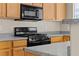 Functional kitchen with wooden cabinetry, granite countertops, and modern black appliances at 5307 Wild Orchid St, North Las Vegas, NV 89031