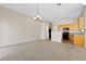 Spacious living room with an adjacent eat-in kitchen that includes wood cabinetry and black appliances at 5307 Wild Orchid St, North Las Vegas, NV 89031