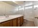 Bathroom features a large mirror, white tile, and light wood cabinets at 5835 Running Horse Dr, North Las Vegas, NV 89081