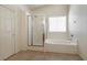 Bathroom featuring a glass-enclosed shower, soaking tub, and large window at 5835 Running Horse Dr, North Las Vegas, NV 89081