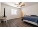 Inviting bedroom with wood-look floors, a ceiling fan and comfortable bed offers a peaceful retreat at 5835 Running Horse Dr, North Las Vegas, NV 89081