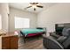 Cozy bedroom features wood-look floors, a comfy bed, and natural light streaming through the window at 5835 Running Horse Dr, North Las Vegas, NV 89081