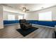 Large bonus room with wood-look floors, a comfortable recliner, and natural light perfect for relaxation at 5835 Running Horse Dr, North Las Vegas, NV 89081