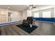 Open bonus room with modern flooring, a comfortable recliner, and bright windows, perfect for entertaining at 5835 Running Horse Dr, North Las Vegas, NV 89081