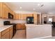 Well-equipped kitchen with oak cabinets, black appliances, and tile floors at 5835 Running Horse Dr, North Las Vegas, NV 89081