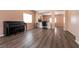 Spacious living room with dark wood-look flooring, large windows, and piano, offers flexibility and comfort at 5835 Running Horse Dr, North Las Vegas, NV 89081