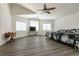 Bright main bedroom with wood-look floors features a large bed, a ceiling fan, and multiple windows at 5835 Running Horse Dr, North Las Vegas, NV 89081