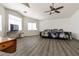 Large main bedroom featuring wood floors, bright windows, and a ceiling fan at 5835 Running Horse Dr, North Las Vegas, NV 89081