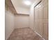 Empty walk-in closet features shelving and neutral tile flooring at 5835 Running Horse Dr, North Las Vegas, NV 89081
