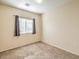 A neutral bedroom features carpet, base molding, a window with blinds and curtains at 5950 Barbosa Dr # 8, North Las Vegas, NV 89031