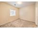 A neutral bedroom features carpet, base molding, and a window with blinds at 5950 Barbosa Dr # 8, North Las Vegas, NV 89031