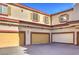 Three garage doors are visible, with yellow and white doors, set against a stucco building at 5950 Barbosa Dr # 8, North Las Vegas, NV 89031