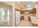Bright kitchen with oak cabinets, white appliances, and view to the living room. Tile floors at 5950 Barbosa Dr # 8, North Las Vegas, NV 89031
