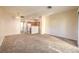 Open living room with neutral carpet, light walls, and view of the kitchen with white appliances at 5950 Barbosa Dr # 8, North Las Vegas, NV 89031