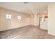 Spacious living room with neutral carpet and light walls. View of windows and doorway to kitchen at 5950 Barbosa Dr # 8, North Las Vegas, NV 89031