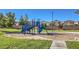 Community playground with green and blue playground equipment on a sunny day at 5950 Barbosa Dr # 8, North Las Vegas, NV 89031