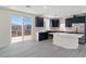 Modern kitchen with dark cabinets, a quartz countertop island, and stainless steel appliances, plus sliding doors to a patio at 6019 Sonoma Station Ave, Las Vegas, NV 89139