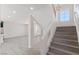 Open staircase with wooden treads and white risers adjacent to large living area at 6019 Sonoma Station Ave, Las Vegas, NV 89139