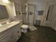 View of a bathroom with a standing shower, decorative mirror, vanity, toilet and gray tile floors at 6500 Hill View Ave, Las Vegas, NV 89107
