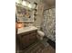 Bathroom featuring a wood cabinet, toilet, shower, vanity mirror, and plants at 6500 Hill View Ave, Las Vegas, NV 89107