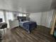 Bedroom with dark wood flooring, a bed with white curtains and a white door at 6500 Hill View Ave, Las Vegas, NV 89107