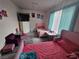 Bedroom area featuring two twin beds, light teal window blinds, an open closet, and a purple chair at 6500 Hill View Ave, Las Vegas, NV 89107