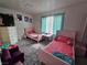 Bedroom area featuring two twin beds, light teal window blinds, an open closet, and a purple chair at 6500 Hill View Ave, Las Vegas, NV 89107