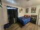 Bright bedroom featuring a blue bedspread, laminate wood floors, and a black window curtain at 6500 Hill View Ave, Las Vegas, NV 89107