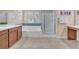 Bright bathroom featuring a bathtub, tiled floors, and glass-door shower at 6659 Alder Flower Ct, North Las Vegas, NV 89084