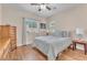 Cozy bedroom with hardwood floors, dresser, and a comfortable bed, illuminated by natural light from the window at 6659 Alder Flower Ct, North Las Vegas, NV 89084