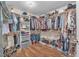 Walk-in closet featuring wooden floors and built-in organizers for clothes and shoes at 6659 Alder Flower Ct, North Las Vegas, NV 89084