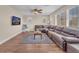 Spacious living room with hardwood floors, a large sectional sofa, and a ceiling fan at 6659 Alder Flower Ct, North Las Vegas, NV 89084