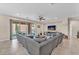 Spacious living room with tile flooring, large sectional sofa, and sliding doors to the backyard at 6659 Alder Flower Ct, North Las Vegas, NV 89084