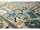 Overhead view of a community center with swimming pool, tennis courts, lawns, and parking area surrounded by homes at 6728 Regency Ridge Ct, Las Vegas, NV 89148